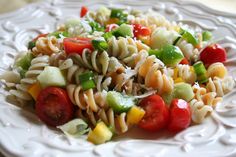 pasta salad with tomatoes, cucumbers, green onions and parmesan cheese