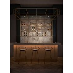 two bar stools in front of a marble counter with bottles on the back wall