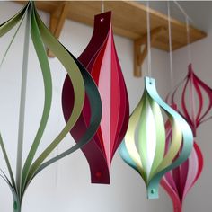 three colorful paper ornaments hanging from the ceiling