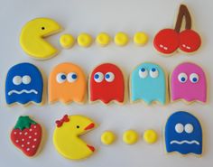 decorated cookies are arranged in the shape of pacman, strawberry, and moon shapes