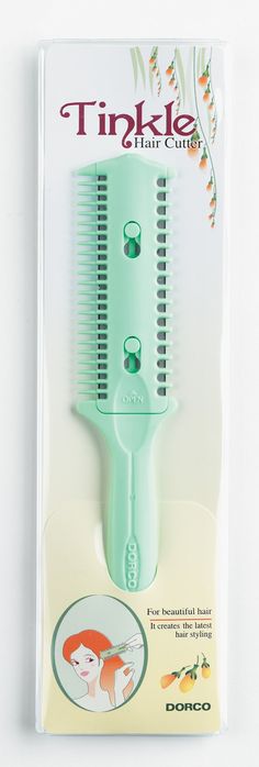 a green comb with an image of a fox on it's side and the words, tinkle hair cuts