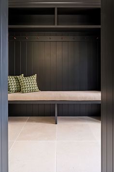 a bench sitting in the middle of a room with black walls and wood paneling