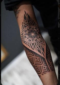 a man's arm with an intricate tattoo design on the left side of his arm