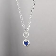 This stunning tiny heart necklace is inlay-ed with 100% natural crushed Crushed Lapis Lazuli Features & Measurements:✦ Sterling silver heart charm - 10.2mm x 7.4mm✦ Inlay is Lapis Lazuli ✦ Dainty sterling silver chain - Choose your length Lapis Lazuli is one of the most sought after stones in use since man's history began. Its deep, celestial blue remains the symbol of royalty and honor, gods and power, spirit and vision. It thought to be a universal symbol of wisdom and truth.Lapis Lazuli i Blue Sterling Silver Jewelry With Heart Charm, Sapphire Sterling Silver Heart Pendant Necklace, Sapphire Heart Pendant Necklace In Sterling Silver, Dainty Blue Round Pendant Necklace, Blue Pendant Charm Necklace For Everyday, Blue Dainty Round Pendant Necklace, Blue Pendant Charm Necklaces For Everyday, Minimalist Birthstone Heart Pendant Charm Necklace, Minimalist Heart Pendant Charm Necklace With Birthstone