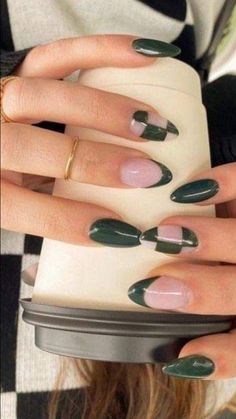 a woman's hands with green and white nail polish on them, holding a tray