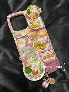 a cell phone case that has many different items on it and is laying on a black cloth