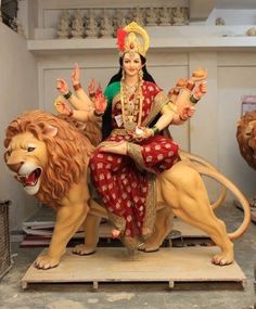 a statue of a woman sitting on top of a lion with her hands in the air