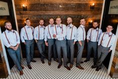 a group of men standing next to each other in front of a wooden wall with lights