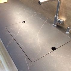 a kitchen counter top with a sink and faucet in the middle of it