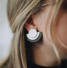 a close up of a person wearing some kind of earring with something on it