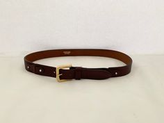 "This is a Metropolitan, genuine leather belt in a rich mahogany brown. It is accented with a gold buckle and silver studs securing decorative leather joiners. Metropolitan leather is produced by the British United Shoe Machinery Company in Leicester, UK which has been in business for over 100 years. If you purchase more than one item from my shop in the same order, I will automatically combine shipping costs and refund your overage.  You can browse my shop at www.etsy.com/ca/shop/trinketsntreas Leicester Uk, Belt With Gold Buckle, Mahogany Brown, Feathered Hairstyles, Brown Belt, Genuine Leather Belt, Suspender Belt, Suspenders, Silver Studs