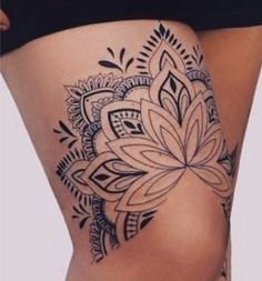 a woman's thigh with an intricate tattoo design on the side of her leg