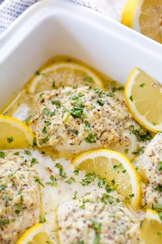 chicken with lemons and herbs in a white casserole