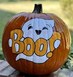 a carved pumpkin with the word boo painted on it's face and paw print