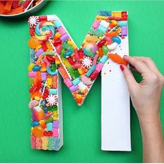 a person is painting the letter m made out of candy