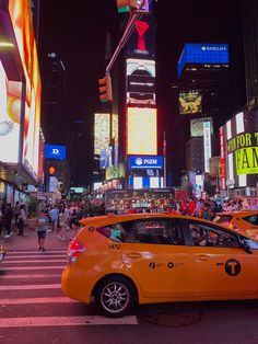 an orange taxi cab driving down a busy city street