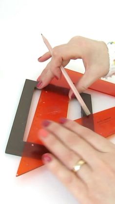 a woman is cutting up some pieces of paper with scissors and glue on top of it