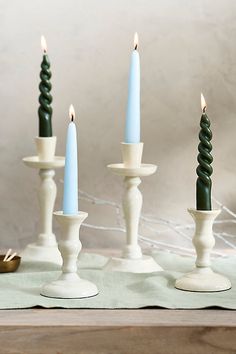 four candles are lined up on a table