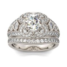 a white gold diamond ring with two rows of diamonds on the band and an oval center stone