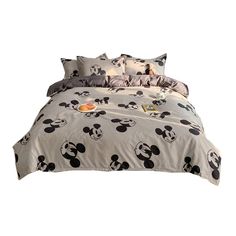 a bed with mickey mouse sheets and pillows