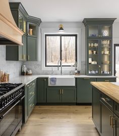 a kitchen with green cabinets and white counter tops