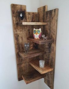 an owl figurine is sitting on top of some shelves in the corner of a room