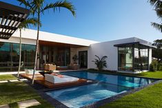 the front cover of a magazine with a pool and lounge chairs in it, surrounded by palm trees