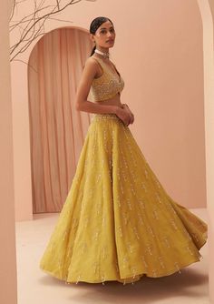 Editors Note Elevate your elegance with this stunning yellow lehenga set adorned with cascading pearls and glistening glass beads. The intricate detailing and exquisite craftsmanship make it a perfect choice for weddings and grand celebrations, ensuring you shine with timeless beauty and grace. Elegant Gold Kundan Palazzo Set, Yellow Embellished Designer Wear Sets, Designer Yellow Embellished Sets, Yellow Kundan Sharara With Intricate Embroidery, Yellow Kundan Set With Intricate Embroidery, Embellished Yellow Sets For Diwali, Embellished Yellow Set For Diwali, Diwali Embellished Yellow Sets, Designer Yellow Georgette Gown