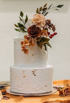 a white wedding cake with flowers on top