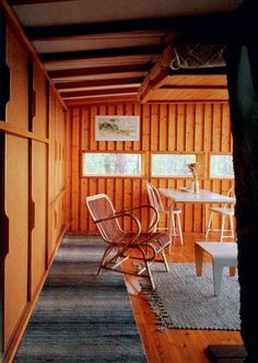 a room with wooden paneling and chairs in the corner next to a rug on the floor