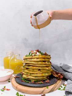 a stack of pancakes being drizzled with syrup