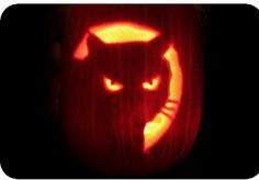 a carved pumpkin with an image of a cat on it's face in the dark