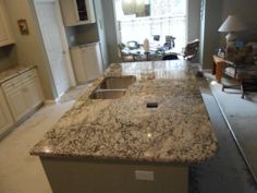 a kitchen counter top sitting in the middle of a living room next to a window