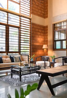 a living room filled with lots of furniture next to large window covered in wooden shutters