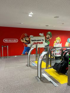 there is a sign that says welcome to japan in front of an entrance with cartoon characters on the wall