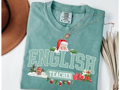 PLEASE NOTE: ALL CHRISTMAS ORDERS MUST BE PLACED ON AND BEFORE DEC. 10TH SO YOUR ORDER WILL ARRIVE ON TIME FOR THE HOLIDAY!A Christmas t-shirt designed for English Teachers, perfect for adding a festive touch to their wardrobe during the holiday season. Ideal for English teachers looking to embrace the Christmas spirit. This unisex garment-dyed Comfort Colors 1717 tee offers a relaxed fit and crew neckline for versatile styling. HOW TO ORDER: 1. Select the desired size and color. See the size ch English Teacher Shirt, English Teacher Gifts, English Teachers, Christmas T Shirt Design, Gift For Teacher, English Teacher, Christmas T Shirt, Size Charts, Embroidery Applique