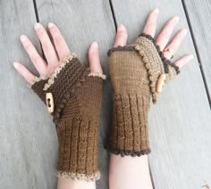 a woman's hands wearing brown knitted mittens and gloves with buttons on them