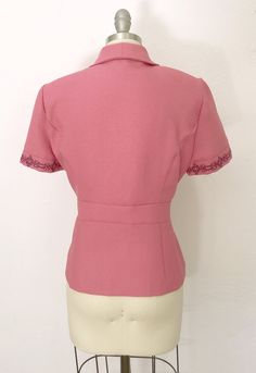 "Vintage victorian peplum blouse. Adorable pink textured fabric with black floral embroidery trim on sleeve cuffs and fitted waist. Buttondown front and snaps at the waist. Cute matching square buttons. Shoulders pads. Fits a modern size medium. See the exact measurement description. Measurements are taken flat and doubled. Fits like a medium Bust: 38\" Waist: 34\" Hip: 38\" Shoulders: 14.5 Length: 24\" Fabric: Polyester Label/Era: Sagharbor Petite / 1990 Condition: Excellent pre-worn condition. Easter Tops, Jacket Blouse, Cute Matching, Peplum Jacket, Peplum Blouse, Button Up Blouse, Vintage Victorian, Suit Separates, Textured Fabric