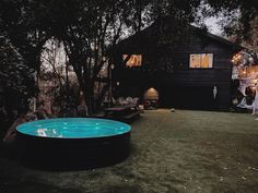 a backyard with an inflatable pool and halloween decorations on the lawn at night