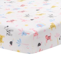 a baby bed sheet with animals and flowers on the sheets is shown in this image