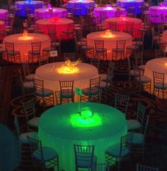 tables and chairs are lit up with colorful lights