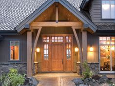 the front entrance to a house with stone steps and pillars leading up to it's entry