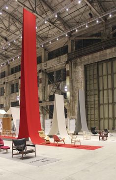 an indoor area with chairs, tables and lights on the ceiling is decorated in white and red