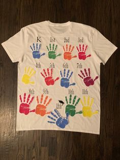 a white t - shirt with handprints on it that says 1st 3rd 5th 6th