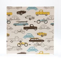 an old car pattern on white fabric with brown and blue cars in the back ground