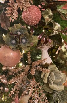 a christmas tree decorated with ornaments and greenery in pink, green and gold colors