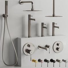 several faucets and shower heads are arranged on the wall