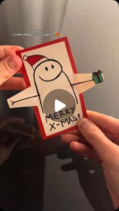 someone holding up a merry x - mas card in their hand