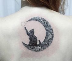 a woman's back with a cat sitting on top of the moon tattoo design