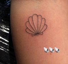 a small tattoo on the back of a woman's left thigh, with three circles around it